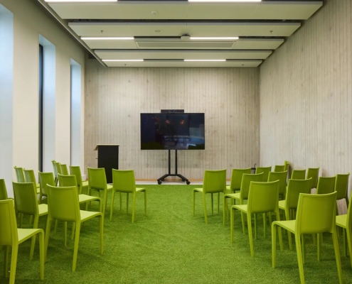 Rustige ruimte met een grote tv voor presentatie en veel groen.