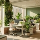 Modern kantoor met groene plantenwanden, tropische planten op bureaus en hangende tuinen in natuurlijk zonlicht