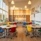 Moderne schoolklas met ergonomische meubilair, kleurrijke verstelbare tafels en stoelen, natuurlijk licht en educatieve wanddisplays