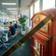 Vintage houten meetlint uitgestrekt over hoek van rode Britse telefooncel in modern kantoor met ergonomische stoelen