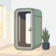 Akoestische telefooncel pod in een licht Nederlands kantoor met houten vloer, witte muren en een klein groen plantje ernaast.